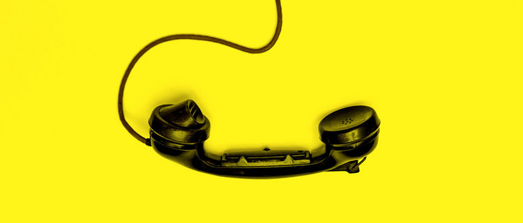 schwarzer Telefonhörer auf gelbem Untergrund